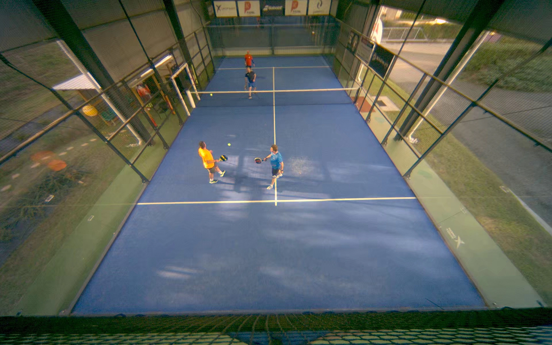Skutečný záběr kamery PadelunAI: čtyři hráči při hře na kurtu Padel Klatovy